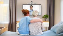 Healthcare worker and patient watching doctor on screen