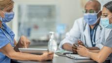 Healthcare worker showing tablet to others