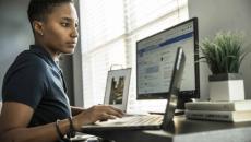 Worker using laptop with external monitor