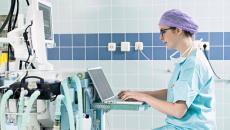 Healthcare worker typing at an operating room workstation