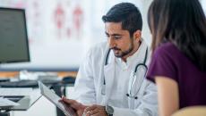 Doctor showing tablet to a patient