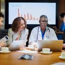 Medical professionals meeting with a graph in the background