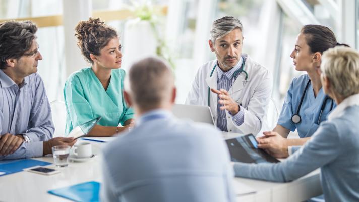 A multidisciplinary team of hospital staff holding a meeting