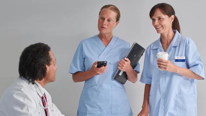 Hospital staff, with one holding the Ascom Myco 4,  in a conversation