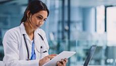 Doctor using tablet and laptop