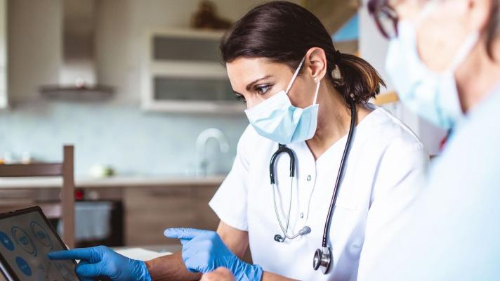 Clinicians consult a tablet