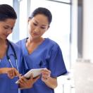 Clinical staff checking on a patient's record on a digital tablet