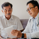 A doctor discussing a patient's health findings using a digital tablet.